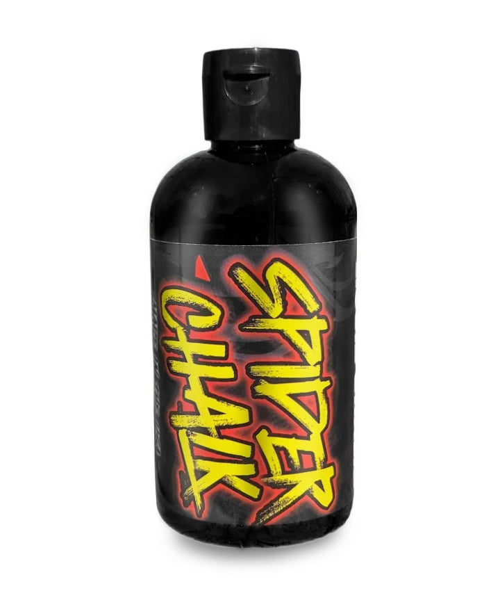 A black bottle of Spider Chalk liquid chalk with red and yellow text and graphics.