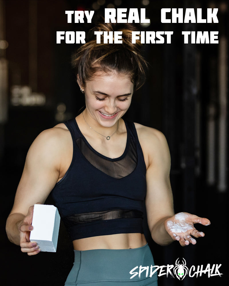 smiling gym girl with block of gym chalk in her hands 